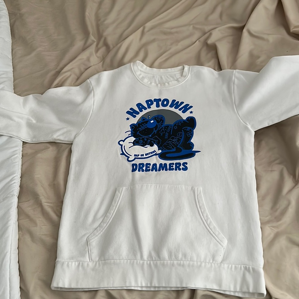 White crewneck with blue black and grey “Naptown” design.